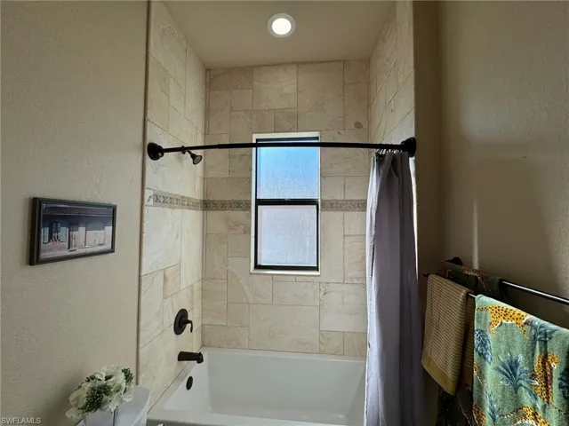 Bathroom featuring shower / bathtub combination with curtain