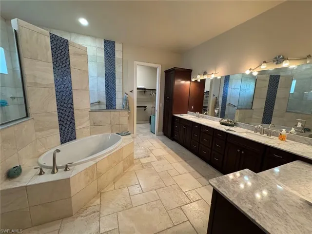 Bathroom featuring vanity and tiled tub