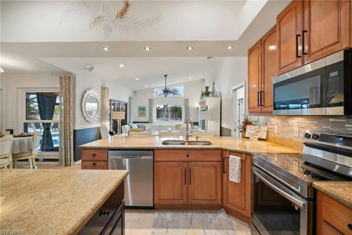 Kitchen featuring tasteful backsplash, stainless steel appliances, sink, lofted ceiling, and ceiling fan