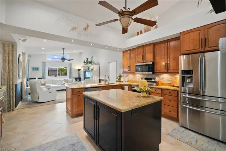Kitchen featuring kitchen peninsula, appliances with stainless steel finishes, light tile patterned floors, and a center island
