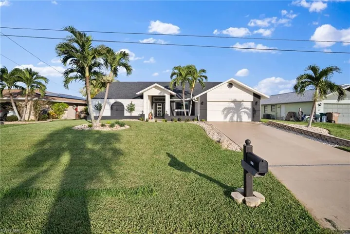 Ranch-style house featuring a garage and a front yard