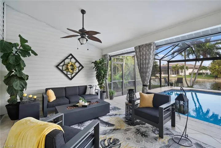Living room with ceiling fan, a water view, and vaulted ceiling