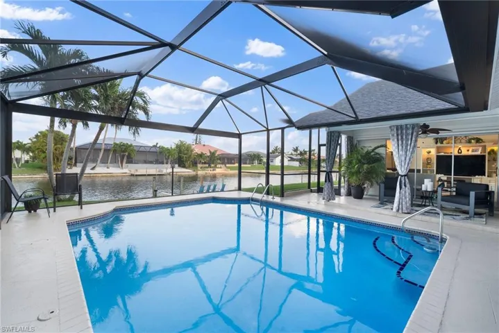 View of swimming pool featuring a patio, a lanai, and ceiling fan