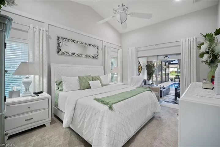 Bedroom with access to outside, multiple windows, vaulted ceiling, and ceiling fan