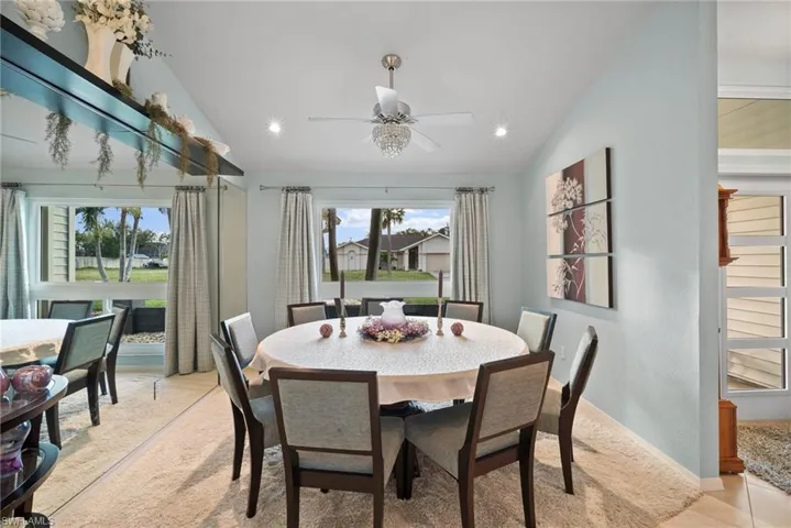 Dining space with light colored carpet, lofted ceiling, and ceiling fan