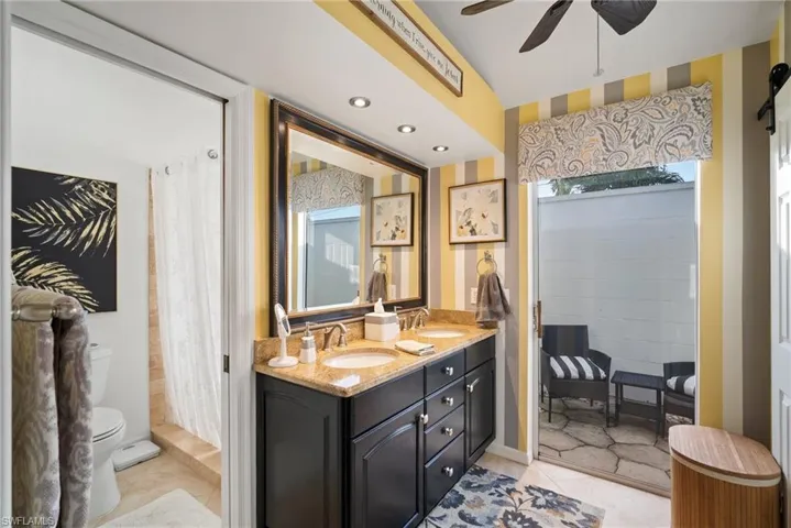 Bathroom featuring tile patterned flooring, vanity, ceiling fan, and toilet