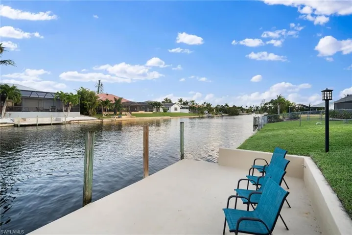 Dock area featuring a water view and a lawn
