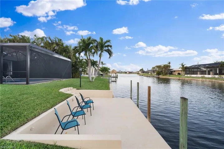 Dock area featuring a yard, glass enclosure, and a water view