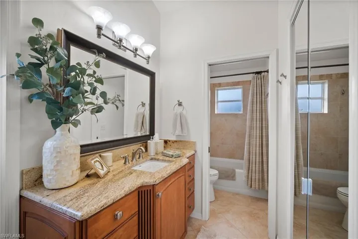 Full bathroom with tile patterned flooring, vanity, toilet, and shower / bath combination with curtain