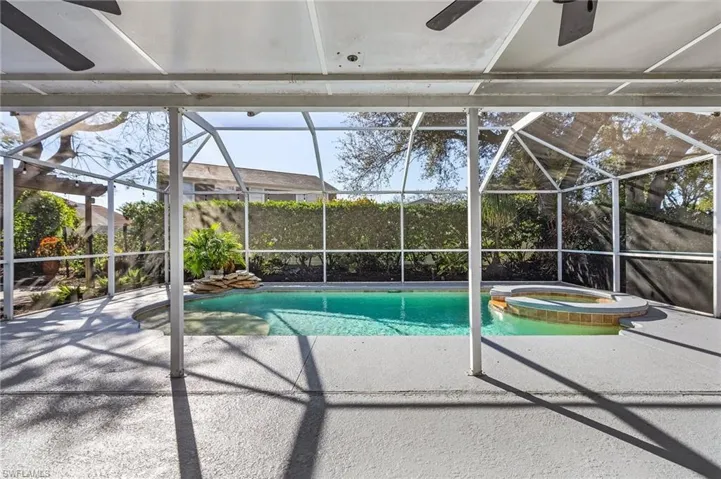 View of swimming pool featuring an in ground hot tub and a lanai