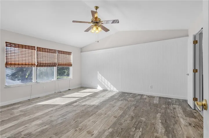 Empty room with light hardwood / wood-style flooring, vaulted ceiling, and ceiling fan