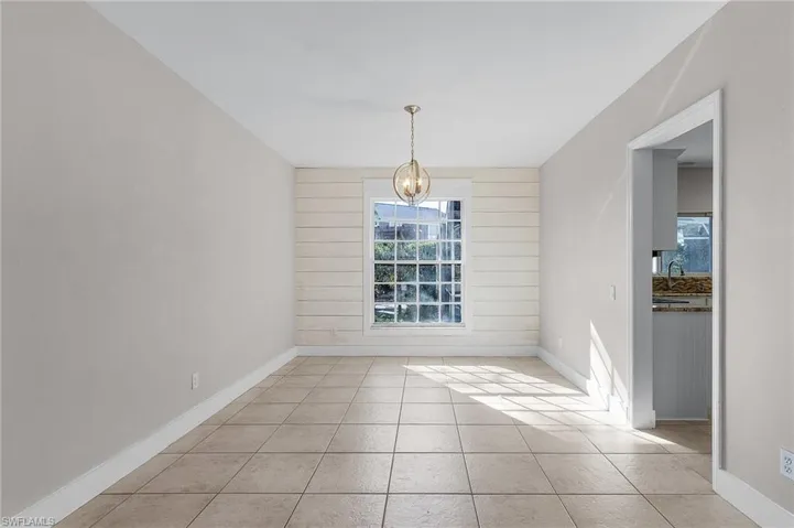 Unfurnished dining area featuring a chandelier, sink, and light tile patterned flooring