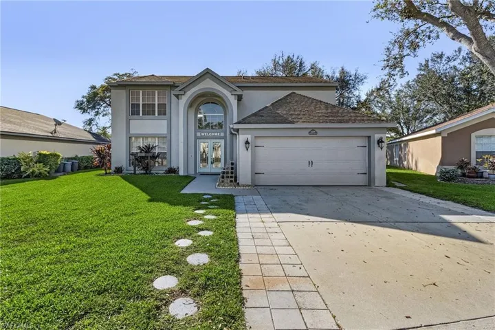 View of property featuring a front yard, french doors, and a garage