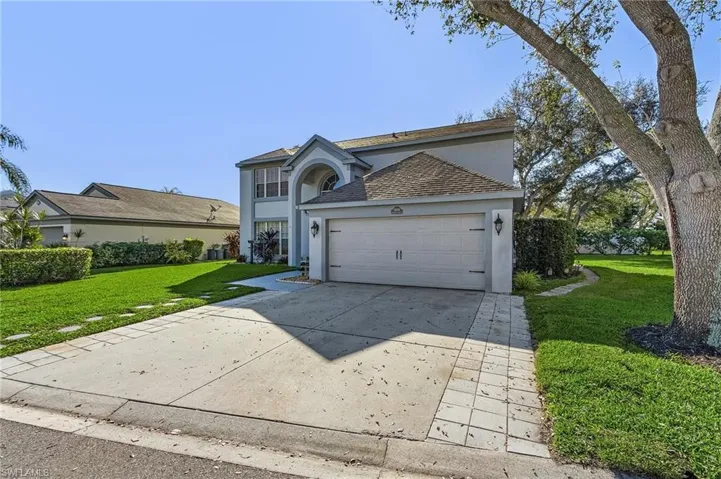 View of property featuring a garage and a front yard