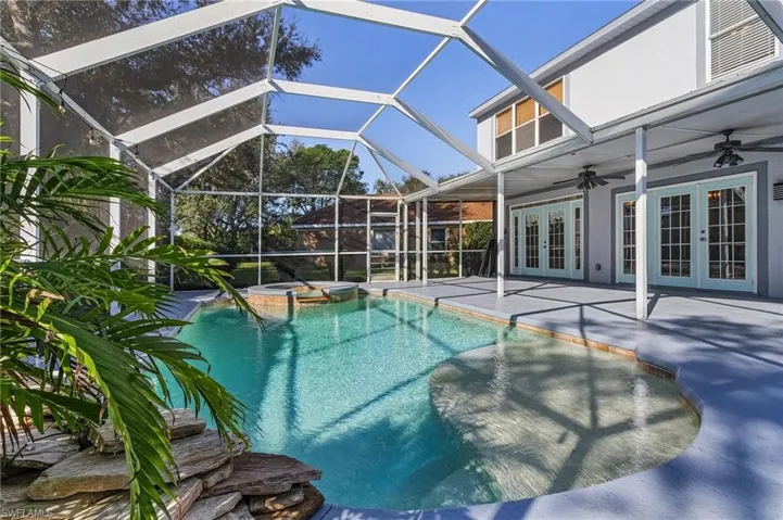 View of swimming pool with an in ground hot tub, french doors, a lanai, ceiling fan, and a patio