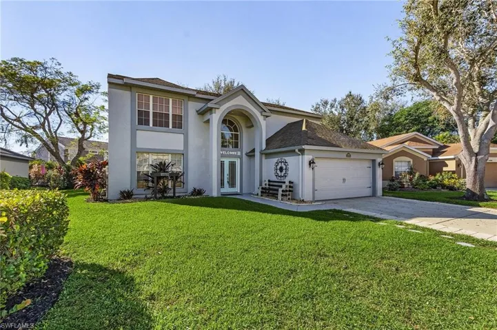 View of front property with a garage, a front yard, and french doors