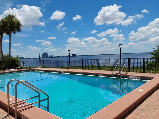 Community pool with a River view, a patio/grill area, and a city view