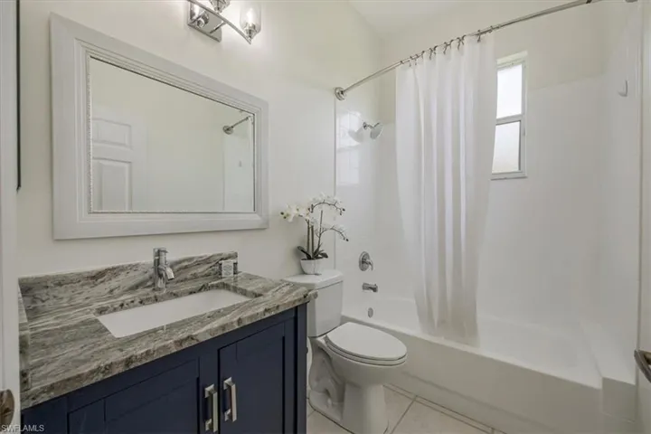 Bathroom with shower / bath combo, vanity, and tile floors