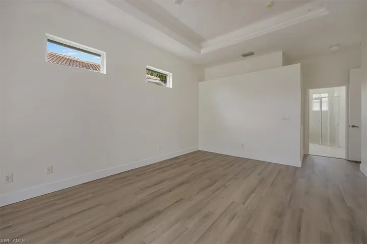 view of primary bedroom and doorway to primary bathroom with walk in closet