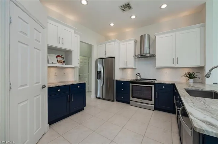 Upgraded kitchen with blue cabinets and stainless steel appliances