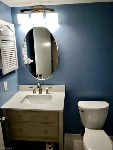 Half bathroom with vanity and tile patterned floors