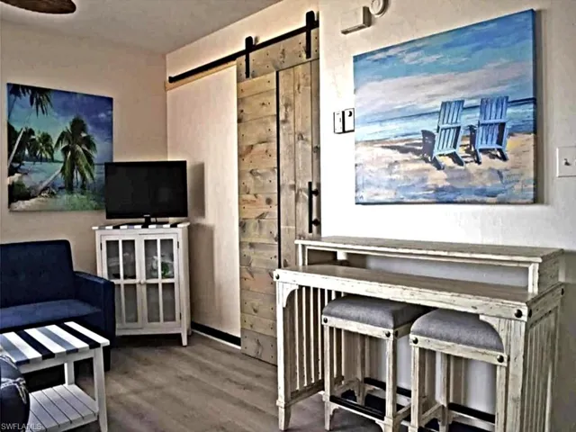 Sitting room featuring a barn door and wood finished floors