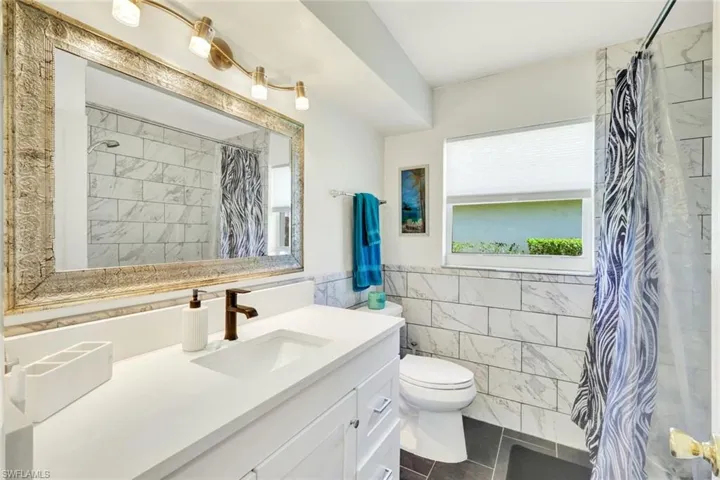 Guest bath with new shaker vanity, tile floors and tub/shower combination.