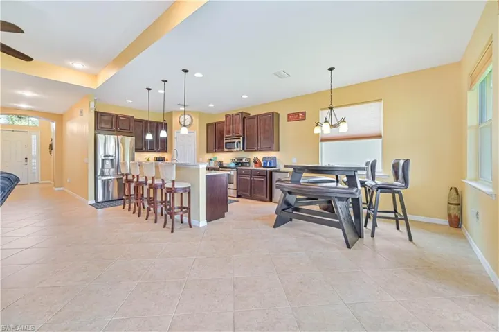 Dining space with a healthy amount of sunlight, light tile patterned floors, and a chandelier