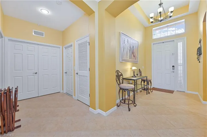 Tiled foyer entrance featuring an inviting chandelier