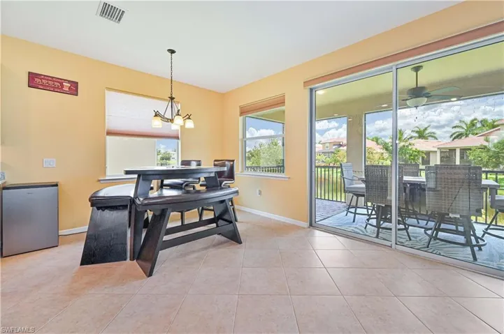 Dining space featuring ceiling fan with notable chandelier and light tile patterned flooring