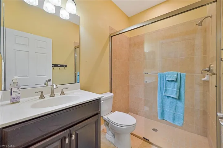 Bathroom featuring vanity, an enclosed shower, tile patterned floors, and toilet