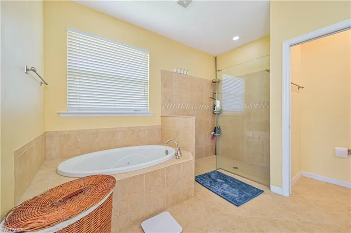 Bathroom with tile patterned floors and shower with separate bathtub
