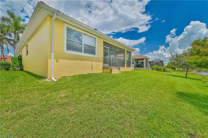 Back of house featuring a lawn and a sunroom