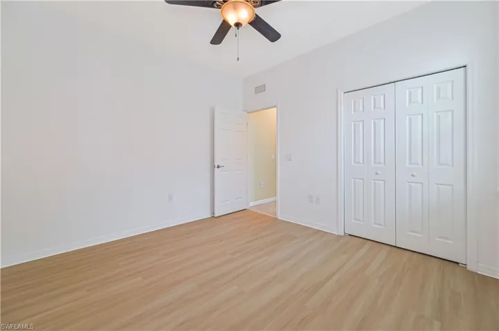 Unfurnished bedroom featuring light hardwood / wood-style floors, a closet, and ceiling fan