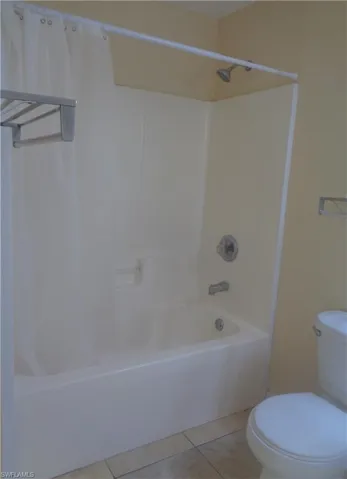 Master bedroom's bathroom featuring shower / tub and toilet and light tile patterned flooring
