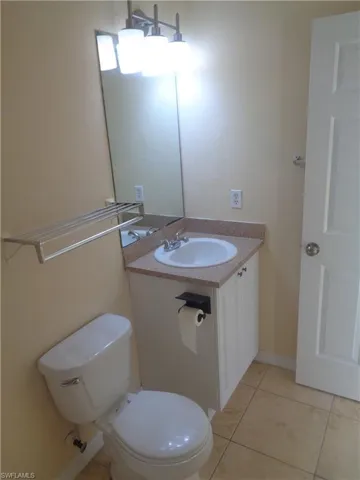 Master bathroom with vanity, toilet and light tile patterned floors