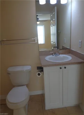Master bedroom's bathroom featuring vanity and toilet and light tile patterned flooring