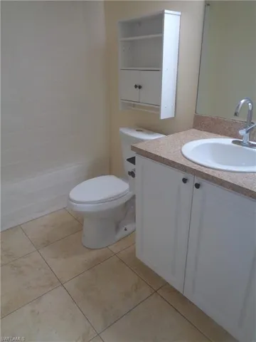 Guest bathroom with vanity, toilet, shower / tub and light tile patterned flooring
