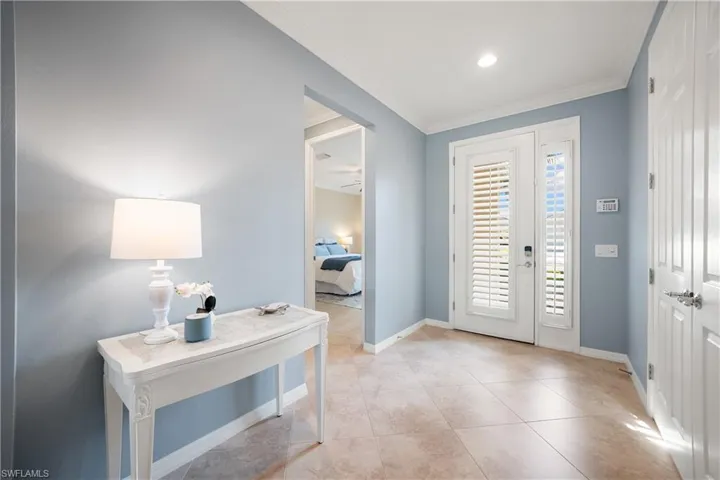 Entryway featuring crown molding and light tile patterned flooring