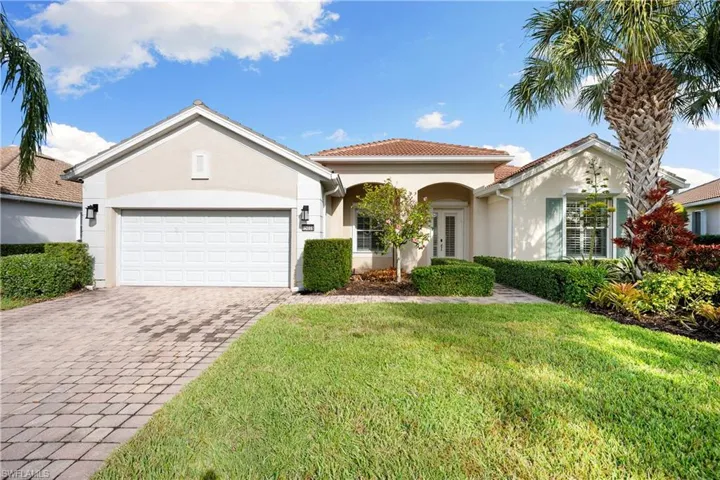 View of front of house with stucco siding, a front lawn, decorative driveway, and an attached garage