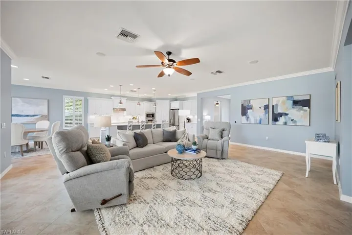 Living area with crown molding, a ceiling fan, and recessed lighting