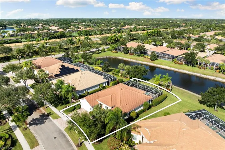 Aerial view of residential area featuring a nearby body of water and property parcel outlined