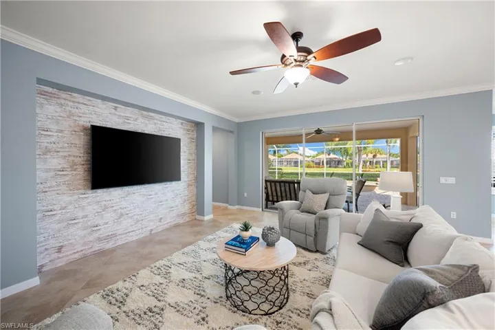 Tiled living area with ornamental molding and a sunroom