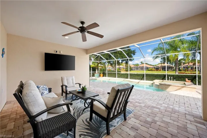 View of patio featuring a sunroom, a lanai, a ceiling fan, a pool with connected hot tub, and an outdoor hangout area