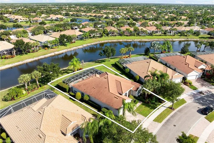 Aerial perspective of suburban area with a nearby body of water and property parcel outlined