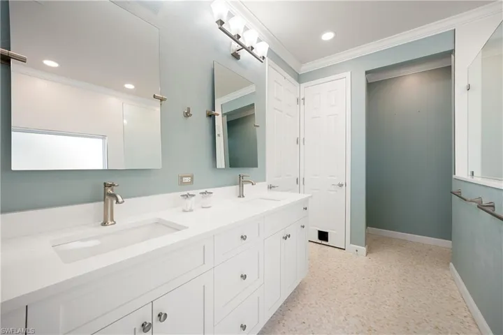Bathroom with double vanity, ornamental molding, and recessed lighting