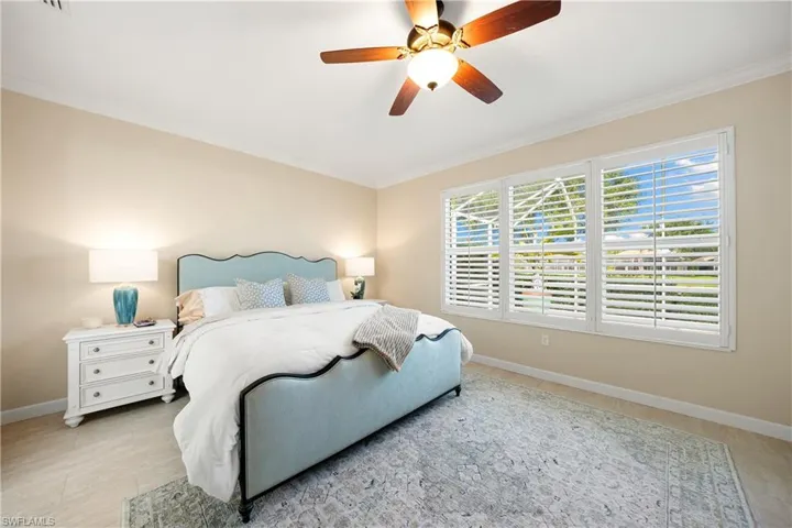 Bedroom featuring ceiling fan and ornamental molding