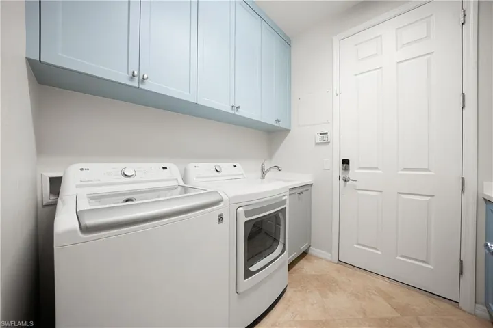 Laundry area with cabinet space and washing machine and clothes dryer