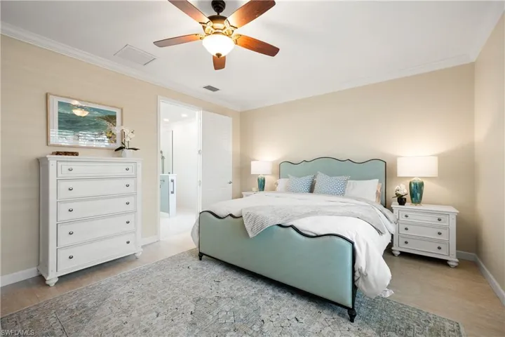Bedroom with ornamental molding, ceiling fan, and light wood-style floors