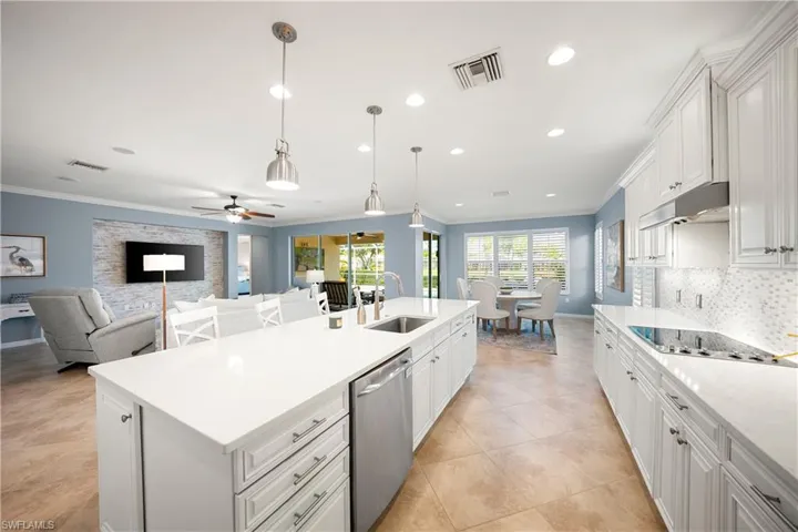 Kitchen featuring white cabinets, open floor plan, pendant lighting, dishwasher, and recessed lighting
